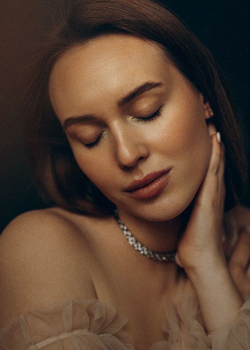 Woman with closed eyes and elegant jewelry.