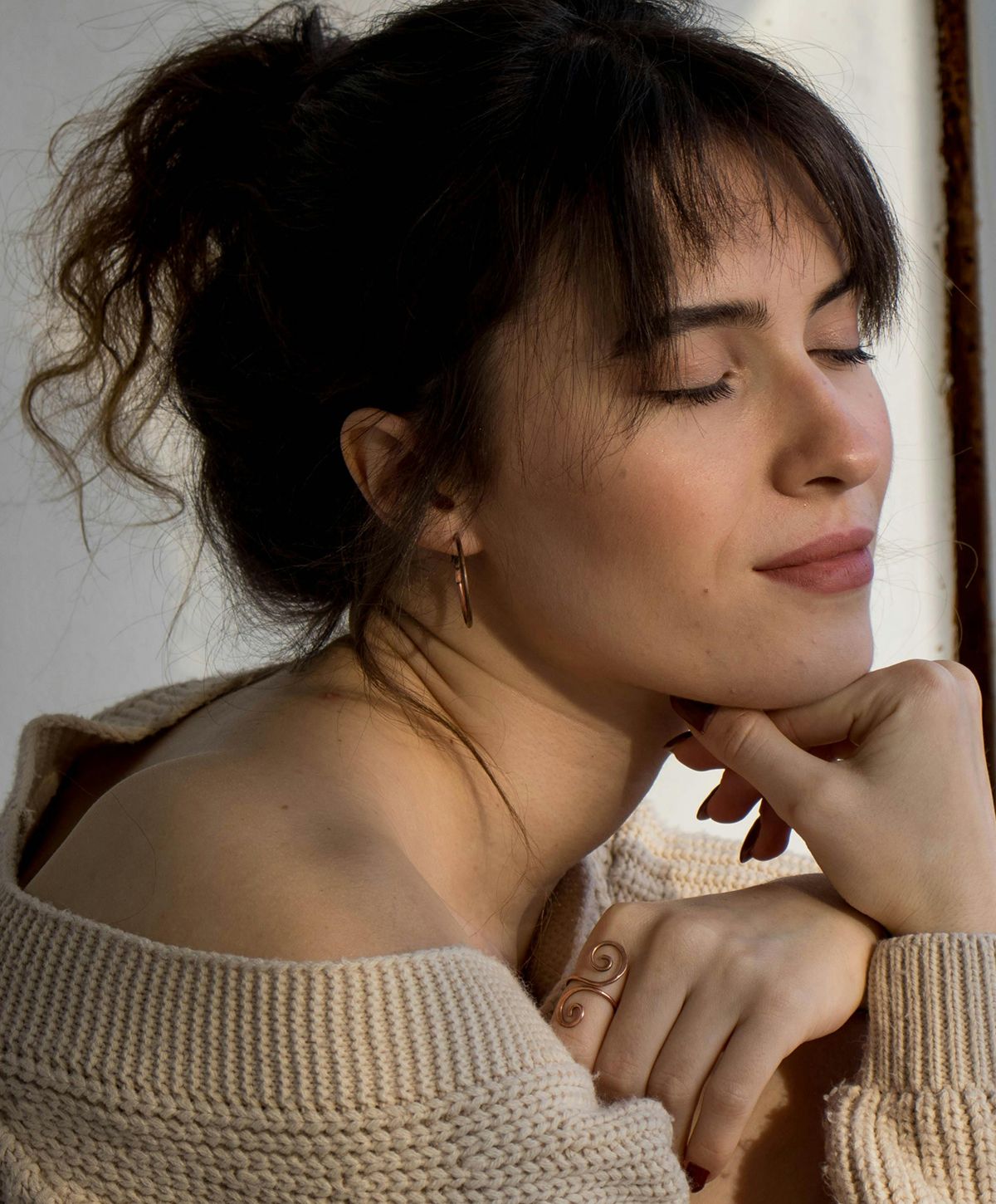 Woman with a thoughtful expression and casual sweater.