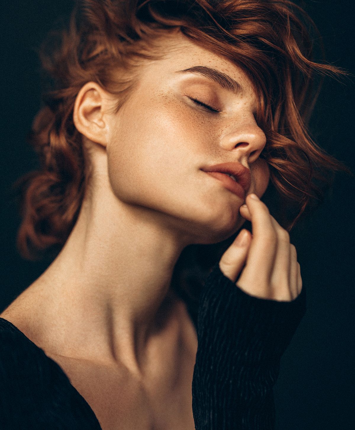 Woman with red hair and soft expression.