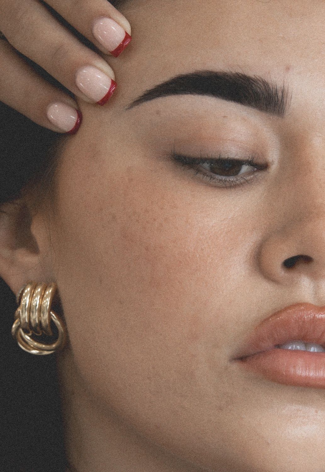 Woman with closed eyes and elegant jewelry.