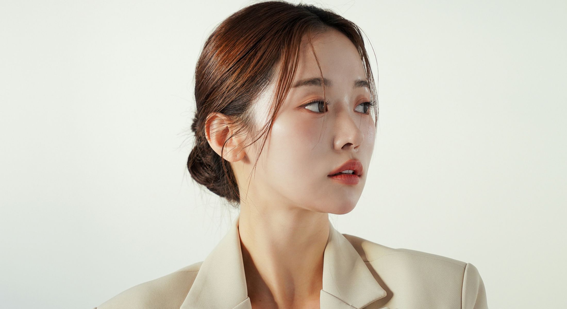 Woman in a blazer looking sideways.