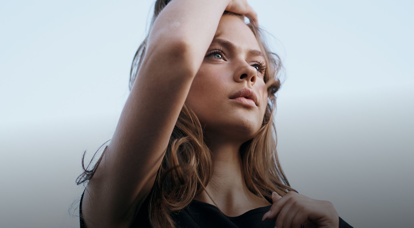 Woman with hand on chin, thoughtful expression.