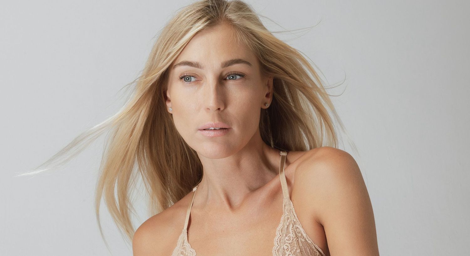 Model with long hair wearing a lace top.